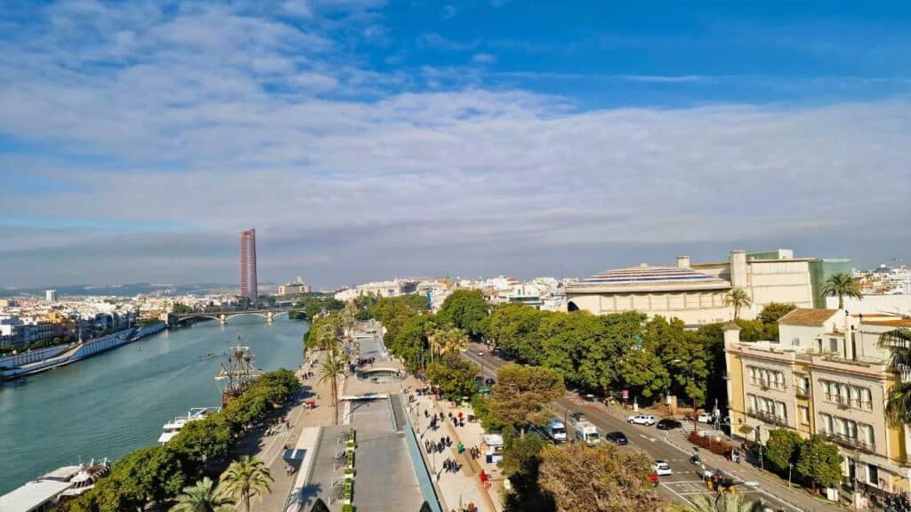 Consigli per Noleggiare un'Auto a Siviglia: La Tua Guida Completa 1 Vista panoramica di Siviglia con il fiume Guadalquivir, la Torre del Oro, il Paseo de Cristóbal Colón e l'edificio del Palazzo di San Telmo.