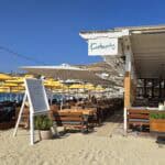 Stabilimento e ristorante Kostantis a Ornos Beach Mykonos, un'opzione di alta qualità con lettini confortevoli e prezzi più abbordabili rispetto alla media dell'isola.