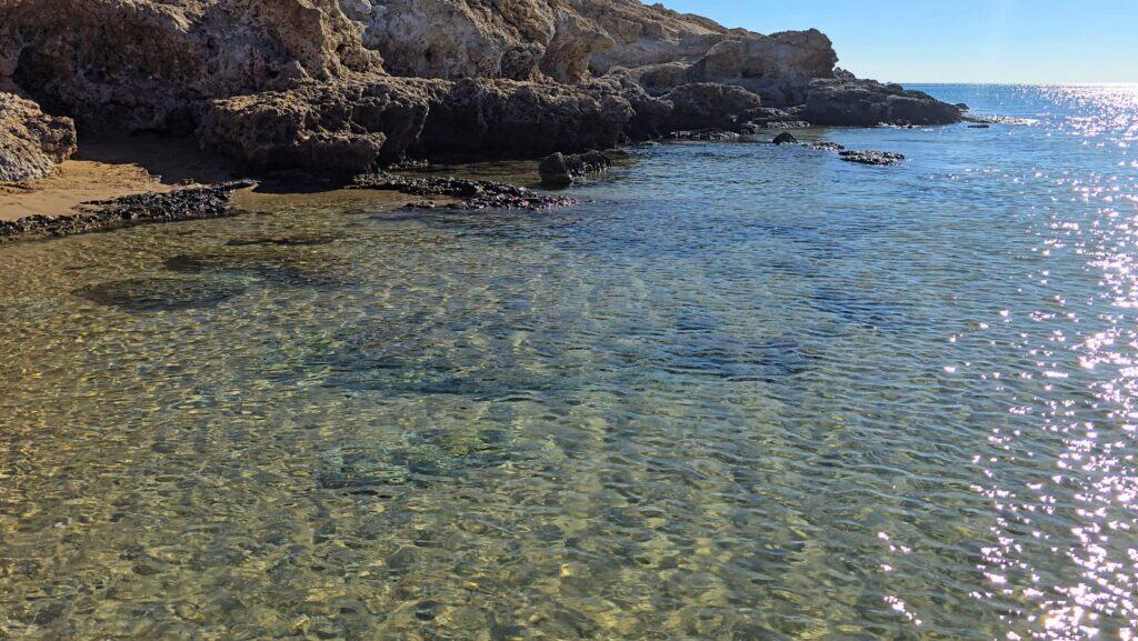 Scopri Agathi Beach (Spiaggia Sant'Agata): L'Essenza della "Sabbia Dorata" sull'Isola di Rodi 2 La zona rocciosa e laterale di Agathi Beach (Rodi), con acqua cristallina e leggermente più profonda, ideale per lo snorkeling e per chi cerca un angolo più selvaggio lontano dalla folla.