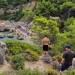 Vista panoramica Baia Anthony Quinn Rodi, mare cristallino verde smeraldo, uomo di spalle sul sentiero