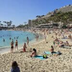 Spiaggia di Anfi del Mar a Gran Canaria gremita di persone a prendere il sole e fare il bagno in pieno gennaio.