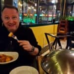 Sorriso di uomo che mangia un piatto di pasta al ristorante di sera.