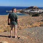 🌅 Lindos di Sera: Tra Acropoli Illuminata e Cene Romantiche sui Tetti di Rodi 2 Vista panoramica di un uomo che osserva il mare e il castello di Roca in Corsica.