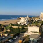 Vista di una zona urbana di Portimão in Algarve a inizio gennaio. Si notano grandi palazzi, una strada principale e l'ampia spiaggia sullo sfondo, a dimostrazione che la città è abbastanza grande e servita per la bassa stagione.