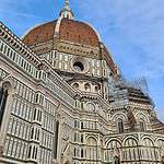 Close-up view of the top of Brunelleschi's Dome in Florence, highlighting the lantern structure and the small, open panoramic balcony that offers an unobstructed view of the city.