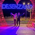 Couple posing in front of a large illuminated heart with "Desenzano" written on it, at night in Desenzano del Garda, Lake Garda, Italy.