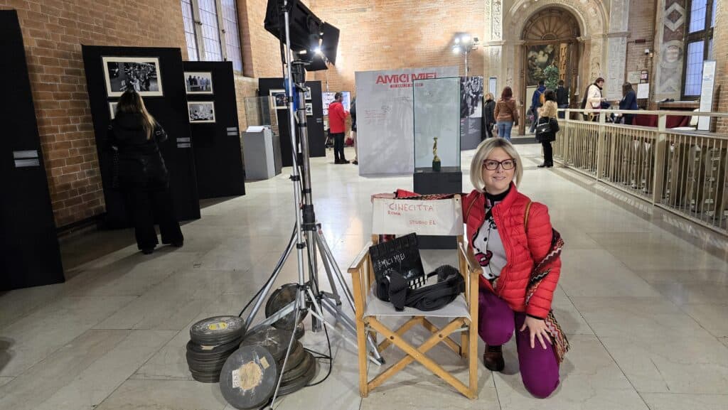 Ila posing next to a director's chair and film equipment at the Ugo Tognazzi film tribute inside Cremona's Town Hall.
