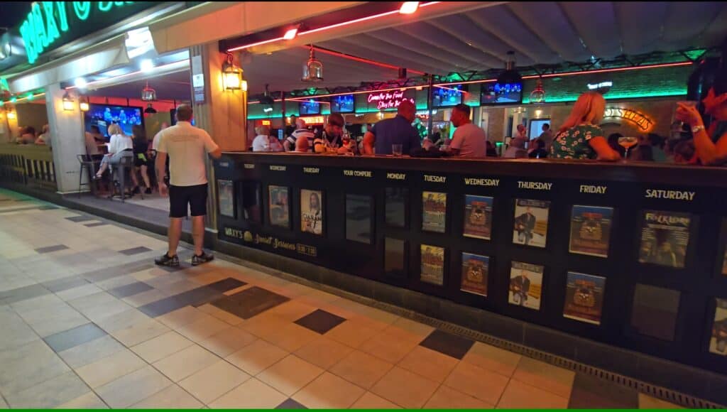 Tenerife Nightlife Expert Guide: How to Find Your Perfect Bar & The Canary Islands Vibe 5 Interior of a British or Irish-style pub in Tenerife with large screens and a stage for live music.