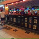 Interior of a British or Irish-style pub in Tenerife with large screens and a stage for live music.