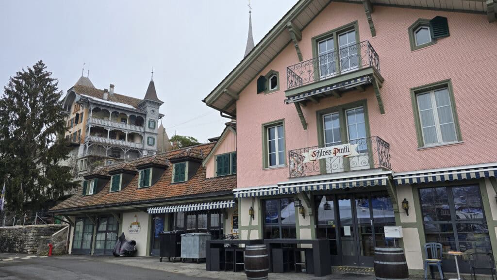 Closed pink restaurant (Schlossli Pinti) near the Spiez boat pier in winter, illustrating the warning about limited dining options off-season.