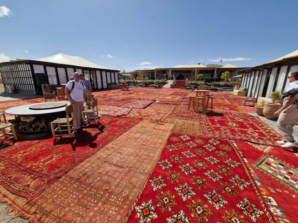 Marrakech Quad Biking: Thrills, Oasis Luxury & The City's Hidden Contrast 5 Vast expanse of traditional red Moroccan carpets laid out on the ground at the desert oasis resort near Marrakech.