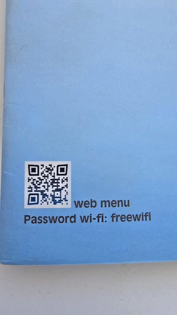 QR Code for the web menu at Cavo Psarou Mykonos and the Wi-Fi password "freewifi", used to check prices and offerings on the beach.