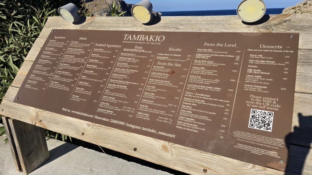 Tambakio Restaurant located directly on the water in St. Paul's Bay, Lindos, showcasing the ultra-luxury, high-budget dining scene.