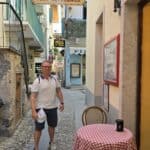 Picturesque narrow street with a traditional pizza and wine bar on Isola Pescatori (Fisherman's Island), showcasing the authentic village charm of Lake Maggiore.