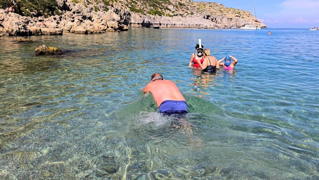 Anthony Quinn Bay, Rhodes: The Emerald Gem of the Aegean (Your 2025 Guide) 2 People snorkeling in the turquoise water at Anthony Quinn Bay, Rhodes, showing excellent underwater visibility