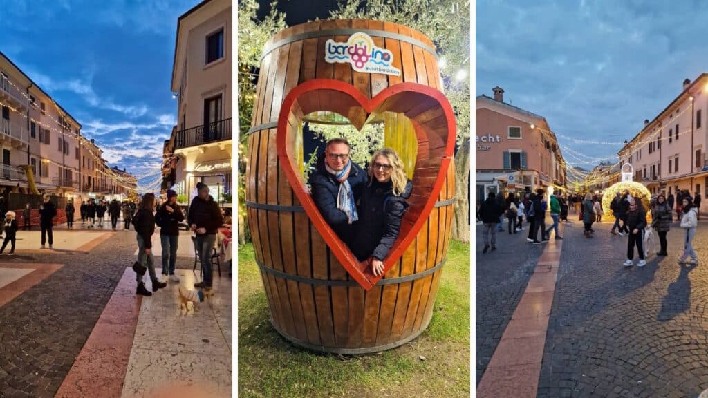 Two people (the author and Gabriel) posing in the center of Bardolino, Lake Garda, with festive Christmas lights visible during a cold December evening.