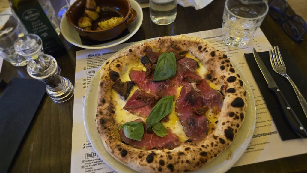 Dining on Lake Maggiore: A Practical Guide to Verbania’s Authentic Flavors 2 Pizza topped with thin Black Angus beef slices and sun-dried tomatoes served at O'Connor Pub in Verbania.