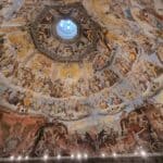Up-close view of the Last Judgment fresco inside Brunelleschi's Dome in Florence, highlighting the painted figures and the internal walkway railing.
