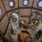 View looking down from the internal walkway of Brunelleschi's Dome into the Florence Cathedral. Image shows the railing, the floor below, and the immense height.