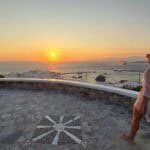 Free viewpoint near a luxury sunset bar in Mykonos, showing a person walking towards the amazing, unobstructed sea view.