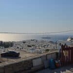 Warning image: An unofficial, unmaintained viewpoint in Mykonos near the sunset area, showing a parked car and lack of safety barriers.