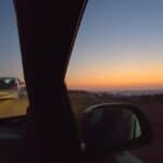 Golden sunset over the Aegean Sea captured from a high vantage point along a Mykonos road, emphasizing the beautiful sky colors.