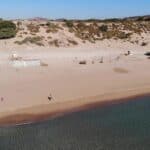 Panoramic view of Agathi Beach Rhodes, showing the free and ample unpaved dirt parking area right next to the golden sand.