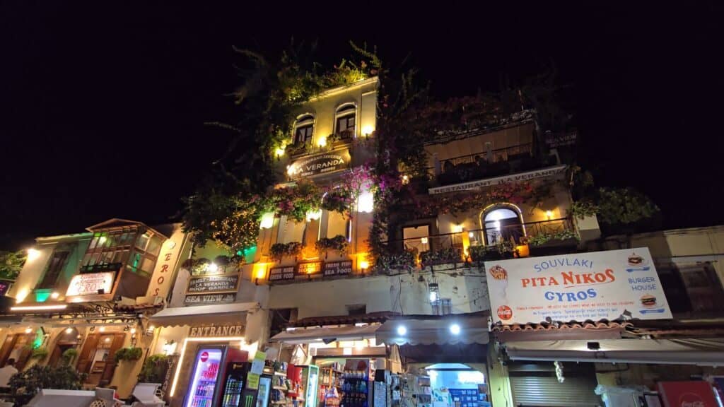Scenic night view of Taverna La Veranda Grill House in Rhodes Old Town, decorated with vibrant climbing flowers, located in Aristotelous Square 40.