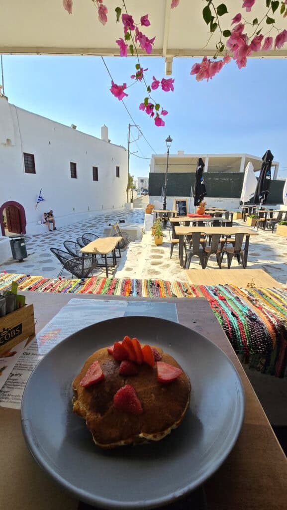 A close-up of delicious pancakes with honey and strawberries served in Ano Mera square, Mykonos.