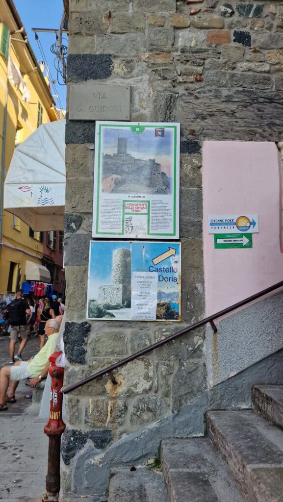 Vernazza Italy: A Gem of the Cinque Terre 5 Sign pointing toward Castello Doria at the base of stone steps in a narrow Vernazza street.