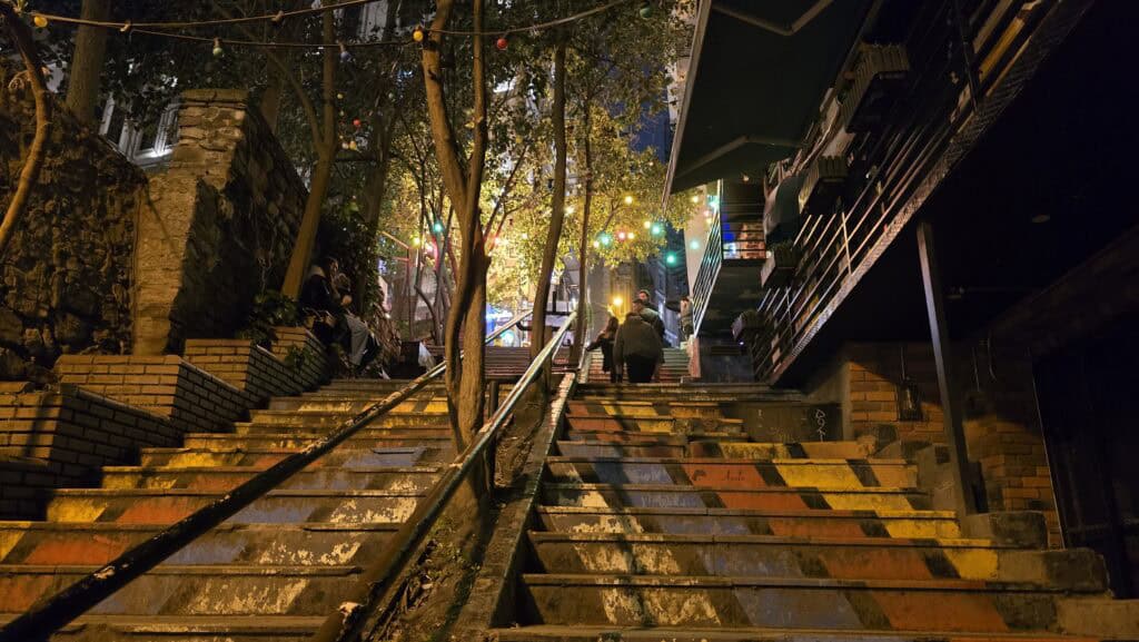 What to See in Istanbul: The Art of Diversifying Sky, Sea, and Underground 1 A narrow, steep cobblestone street in Istanbul’s Galata district, showing a long flight of stone stairs rising between historic buildings, leading toward the Galata Tower area.