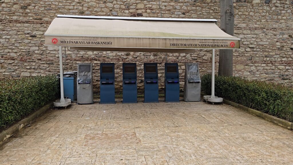 A row of automated ticket machines turned off and out of service under an awning at the entrance courtyard of Topkapi Palace in Istanbul.