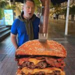 Large, supersized hamburger and fries served on a plate in a Tenerife tourist restaurant.