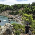 Anthony Quinn Bay Rhodes aerial view, crystal clear emerald green sea, man on hiking trail looking down at beach