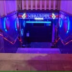 Neon-lit entrance to Megabowl Tenerife, a bowling alley in Costa Adeje, with stairs leading down.