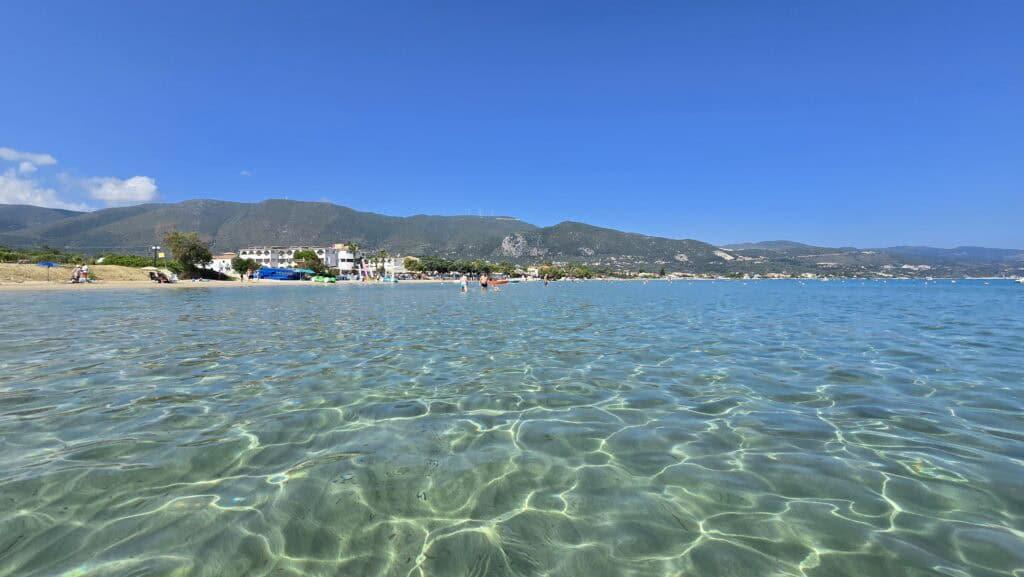 Unedited photo of Alykanas Beach in Zakynthos Greece with crystal clear turquoise water resembling a natural swimming pool on a sunny day